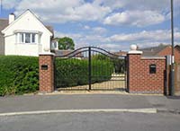 A steel gate with a double middle rail and serpentine curved double top rail