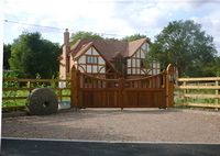 A Derby style gate is boarded on the bottom section with the top section having wooden infill bars with a concave top bar