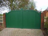 A pair of 'Derby' gates painted green. The 'Derby' design has a single convex curve flattening out towards the centre giving a slightly more imposing look than the Buxton design.