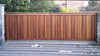 A modern looking wooden flat topped sliding gate
